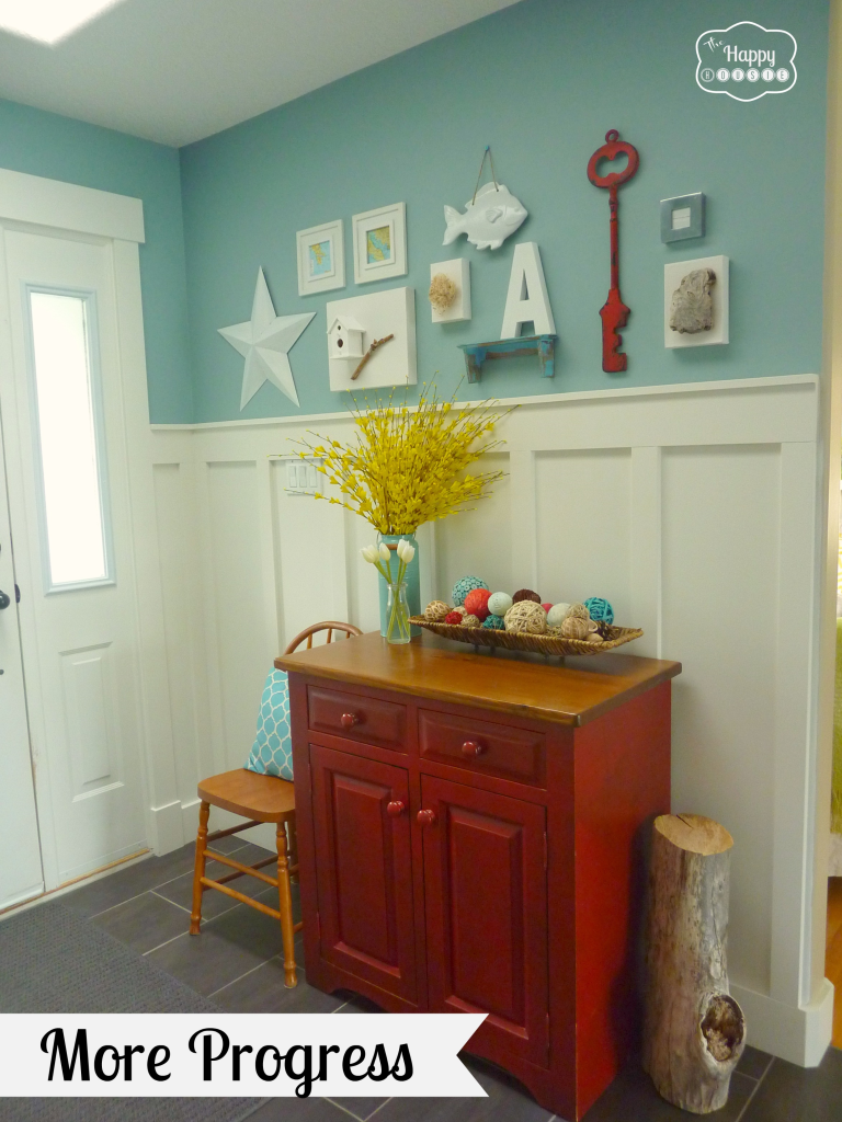 The entryway painted a light blue, with a wooden sideboard.