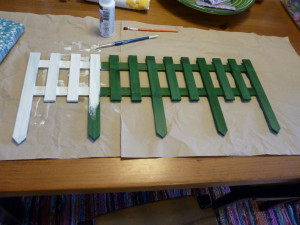 Painting the green picket fence white.