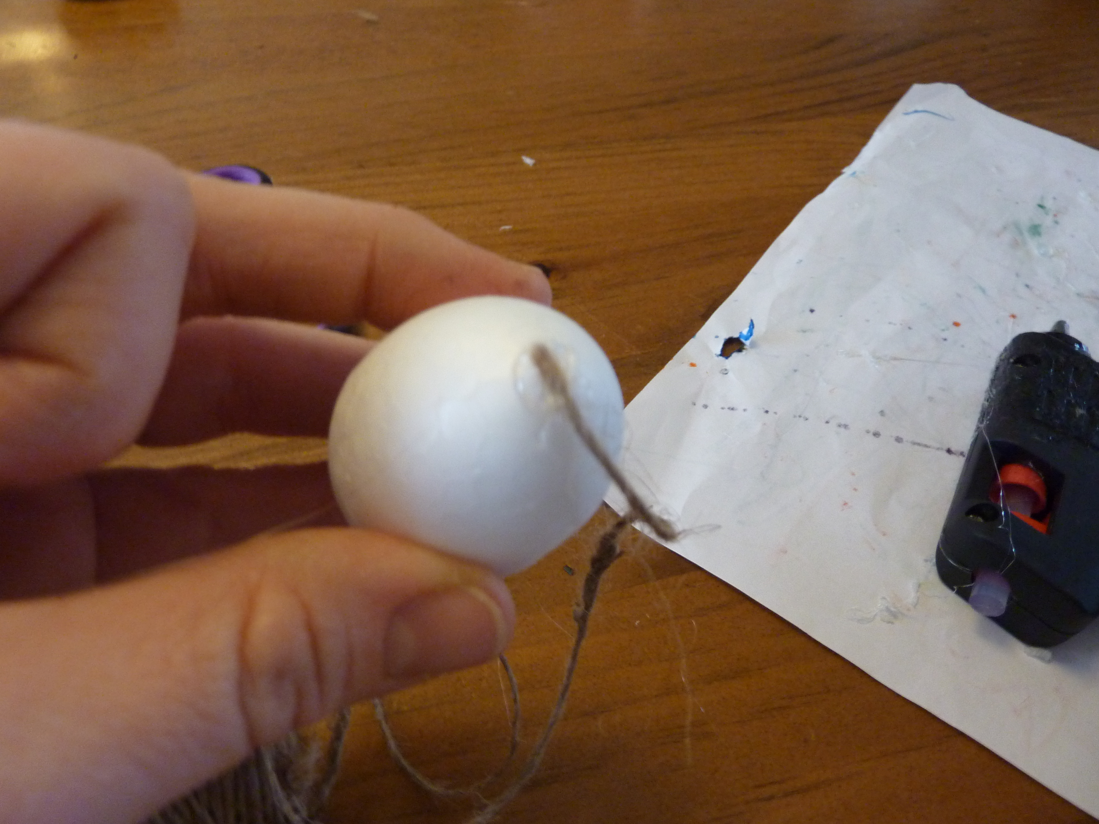 Using hot glue on the tip of the egg.
