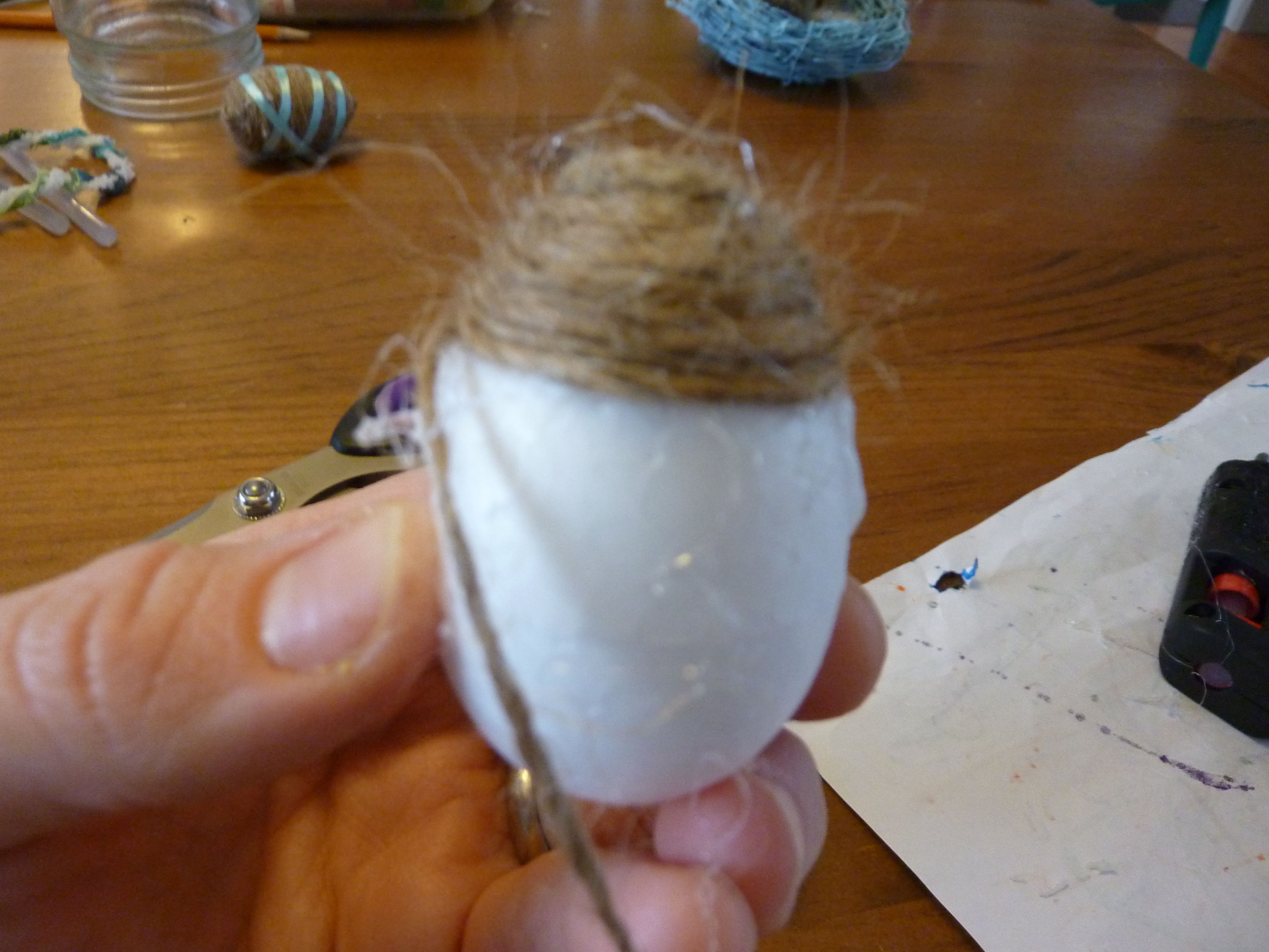The egg being wrapped by twine.