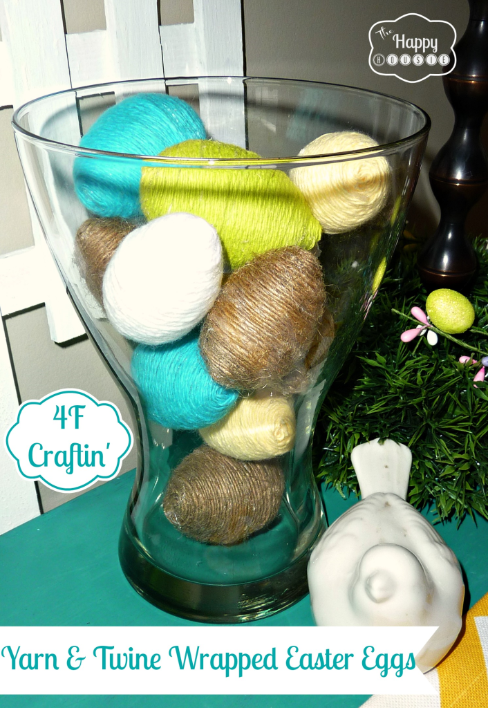 yarn twine wrapped easter eggs in a clear glass vase.