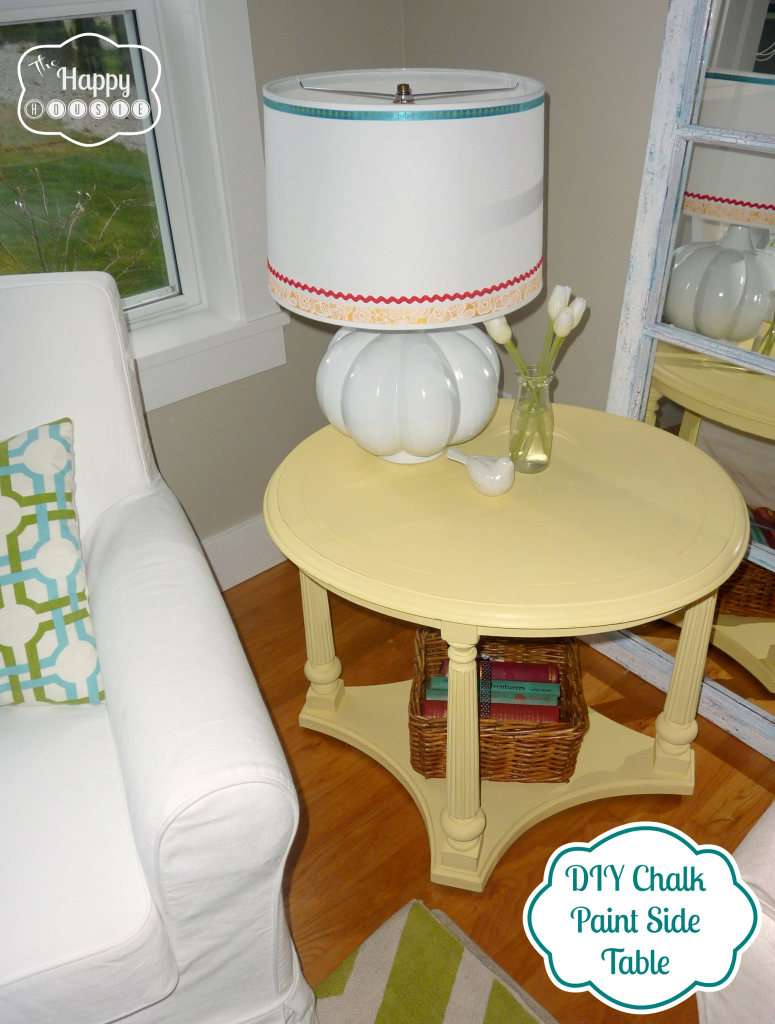 A yellow side table with a lamp on it.