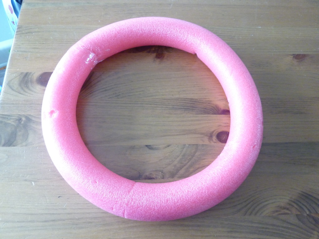 A pink pool noodle on the floor.