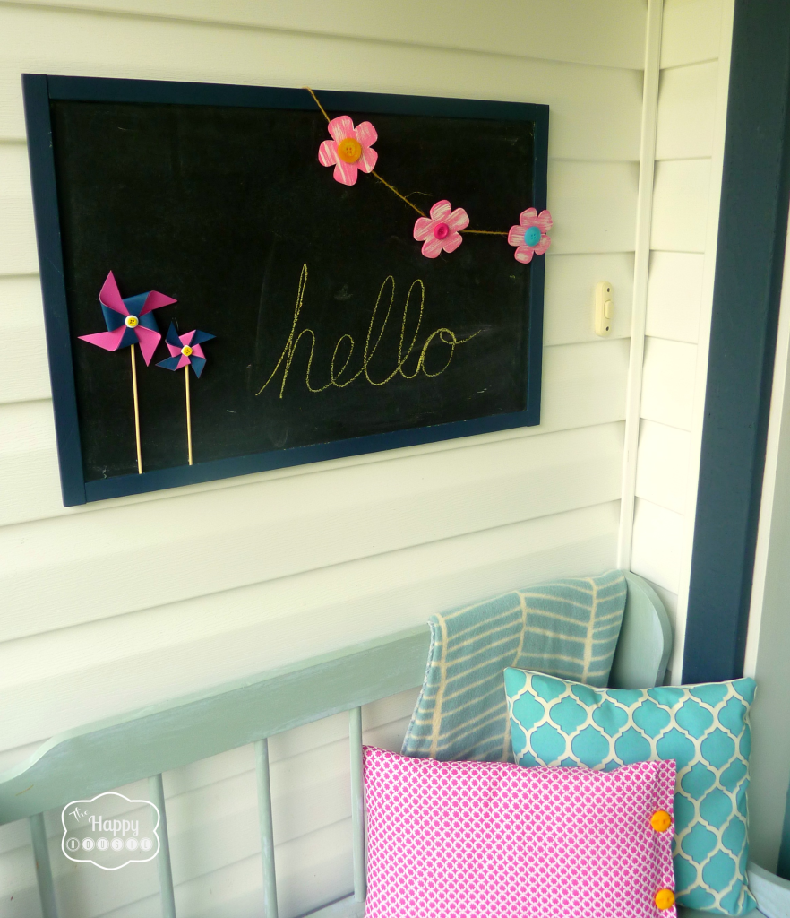 A chalkboard with the pinwheels and flowers on it.
