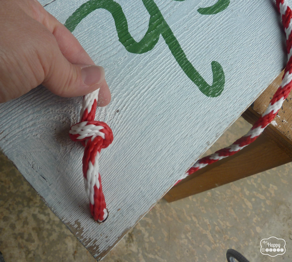 Attaching rope to the sign for hanging.