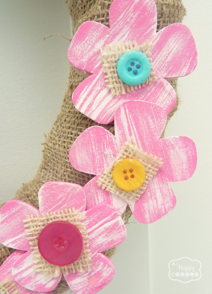 Buttons and burlap on the flowers on the wreath.