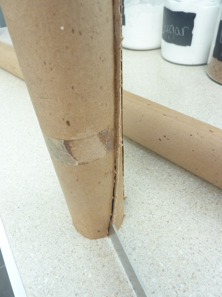 Slicing the side of the cardboard tube.