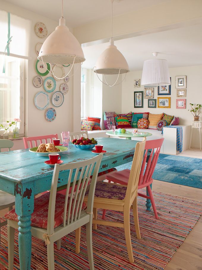 A turquoise wooden table and a an area rug multi coloured.