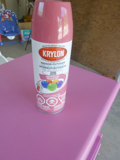 A can of krylon watermelon pink on top of the nightstand.