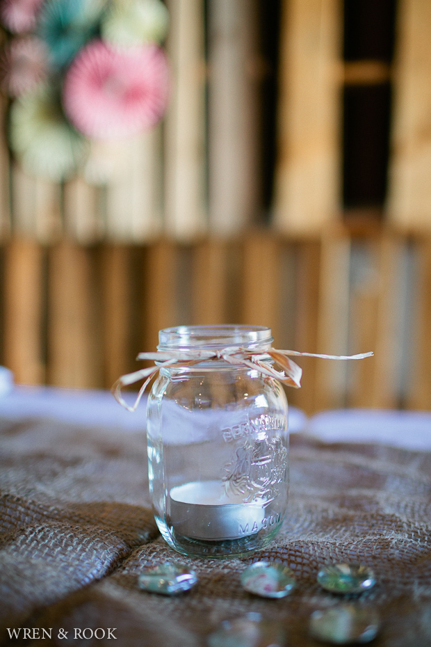 A mason jar with a small tea light candle in it.