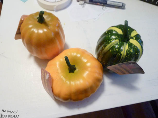 Faux plastic pumpkins on a white tray.