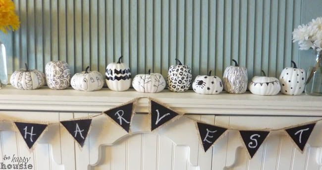The pumpkins on a mantel displayed with a banner.