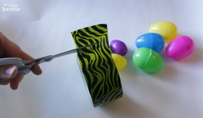 Using the duck tape to tape the plastic eggs.