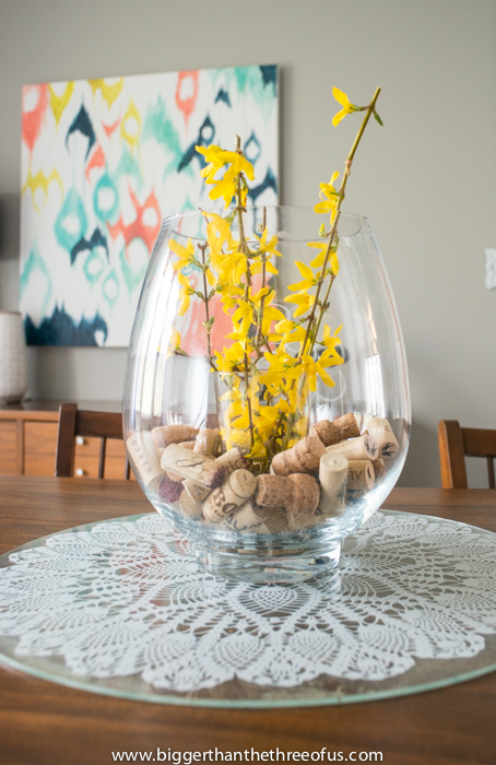 Bigger Then Dining Room with a large clear vase filled with yellow flowers.