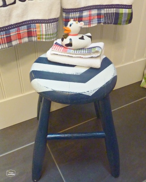 The stool in the bathroom with a rubber toy on top of it.