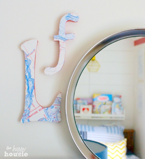 The map letters on the wall beside a mirror.