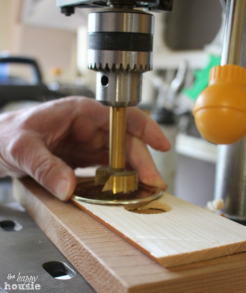 Using a drill press to cut the hole in the lid.