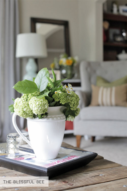 A white pitcher with hydrangeas in it.