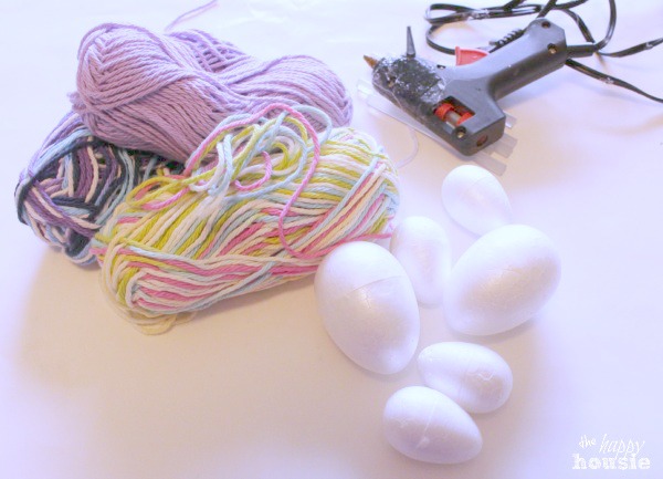 The hot glue gun, yarn and eggs laid out.