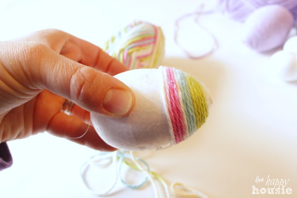 Wrapping colourful yarn around the eggs.