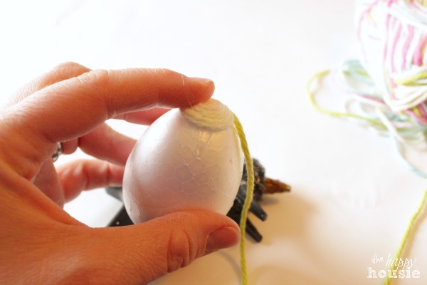The hot glue on the egg and wrapping the yarn.