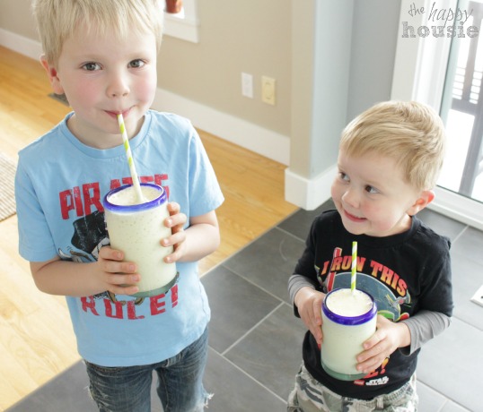 Two little boys drinking the smoothie.