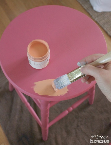 The stool painted a bright pink and a soft peach.