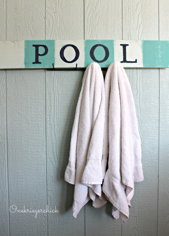 A DIY pool sign with towels hanging on it.