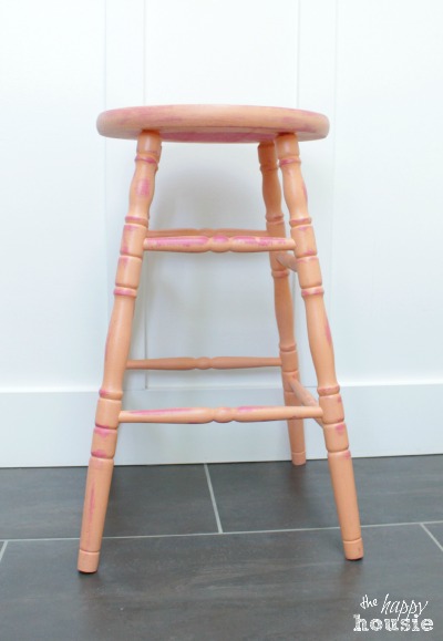 The distressed stool with hints of pink peeking out.