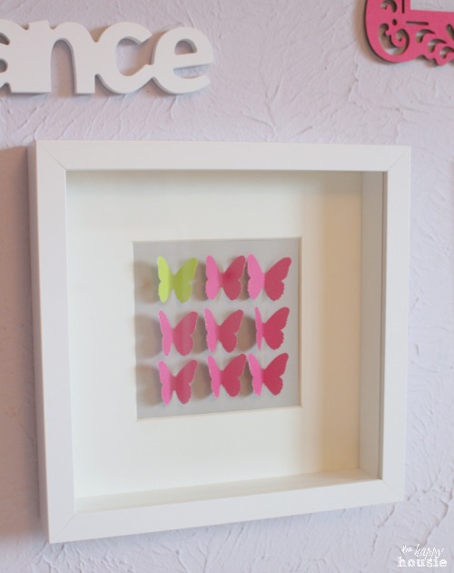 All pink and one yellow butterfly art on the wall.