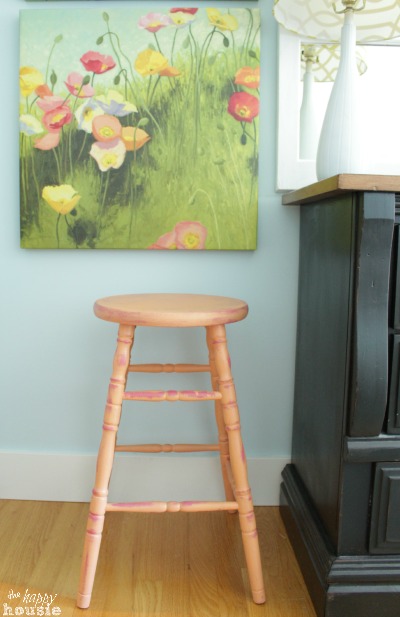 The stool with a vibrant garden picture above it.