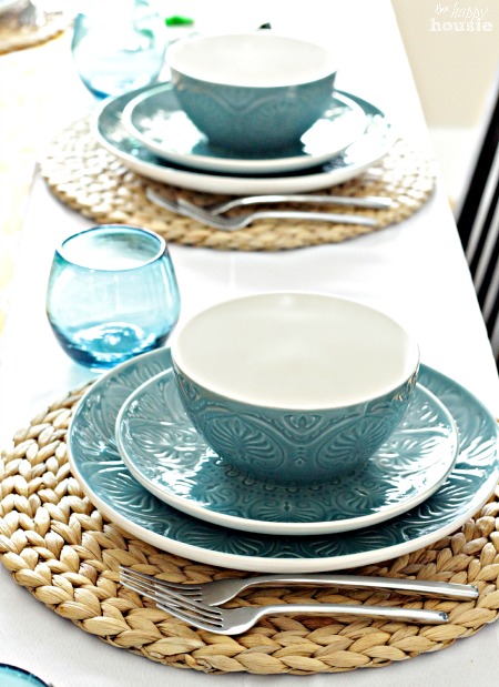The table setting with clear blue glasses.