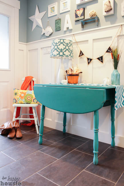 A small wooden console table painted turquoise.
