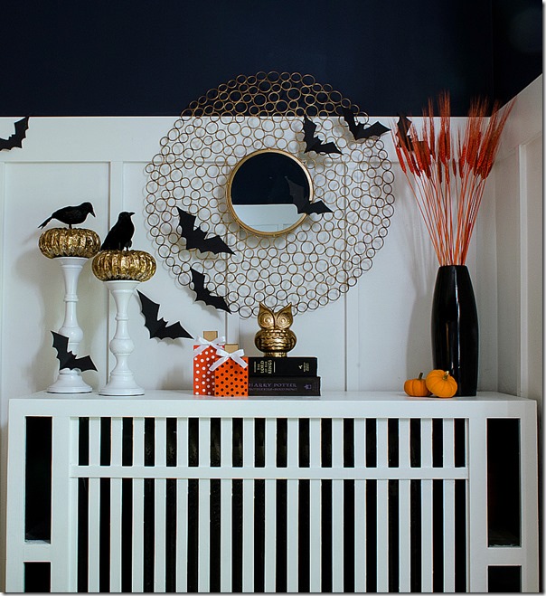 A Halloween mantel that have flying bats, crows and an owl.