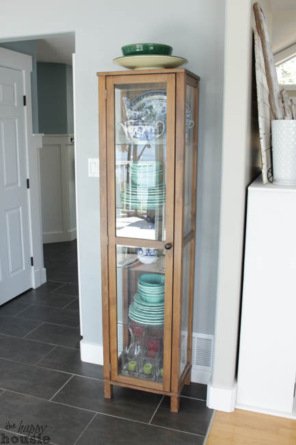 The small cabinet with glass doors and small shelves.