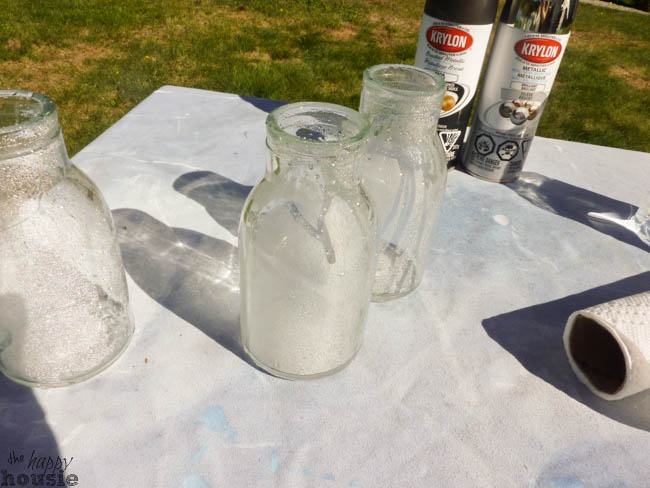 Spraying vinegar into the glass bottles.