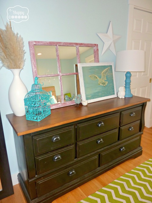 The old dresser with its brown look and lamps and pictures on top of it.