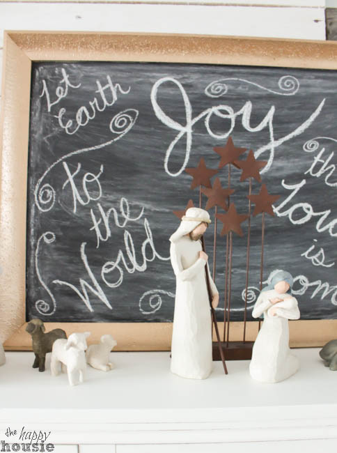 A small nativity scene is in front of the chalkboard.