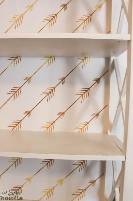 Up close picture of the white bookshelf with the wallpaper on it.
