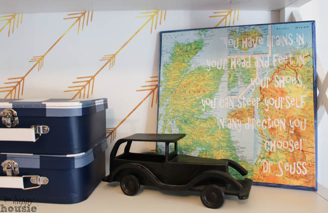 A small toy truck, and a map on the bookshelf.