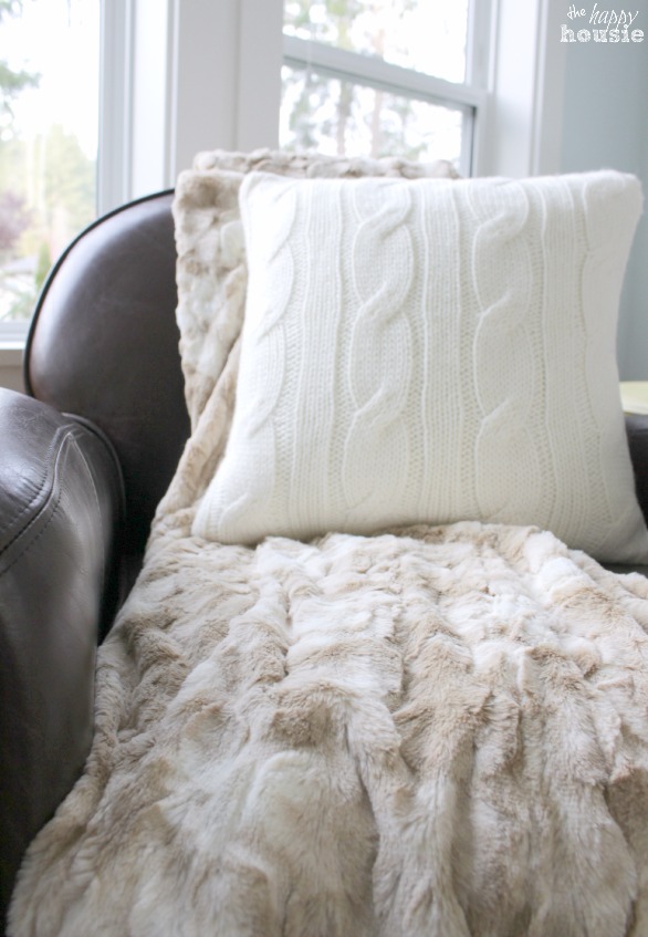 The white cable knit pillow on the armchair.