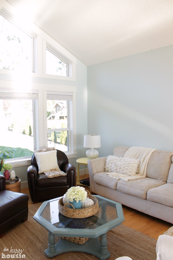 Whispering Spring by Benjamin Moore in the living room on the walls, a light blue and glass hexagon coffee table in the living room.