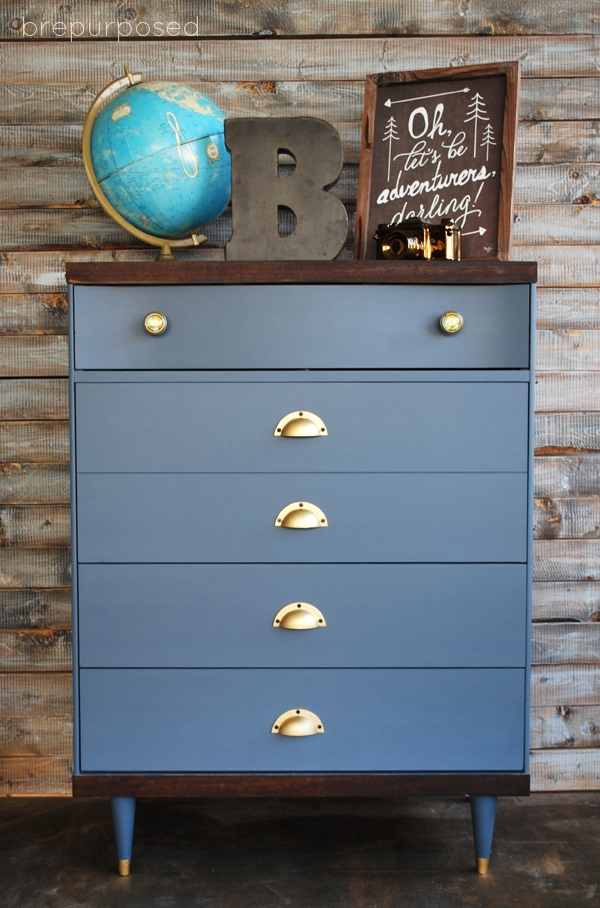 A slate blue dresser with a globe on top.