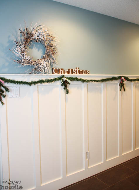 There is a garland on the board and batten wall.