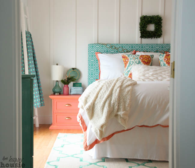 A boxwood wreath is at the head of the bed on the wall.