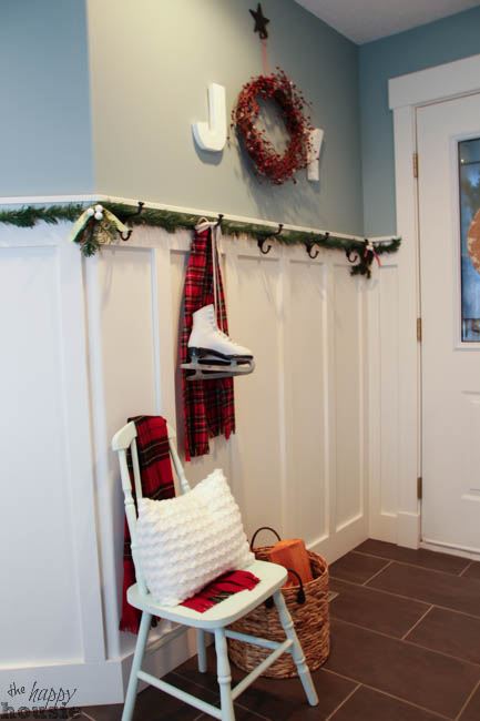 A white chair is in the entryway with a tartan throw blanket on it.