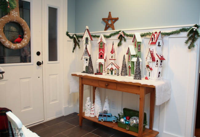 The entryway has a small table filled with a Christmas scene.