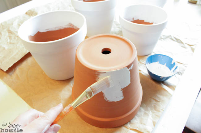 Painting the clay pots white.