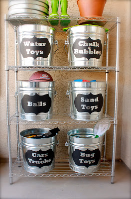 Organizing Outside Toys with Buckets on a metal shelf outside.