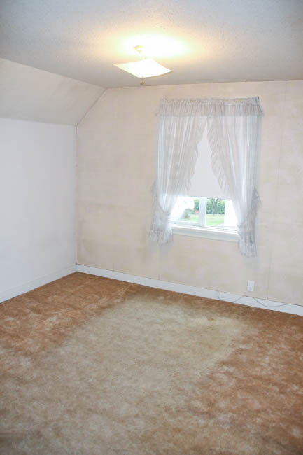One bedroom with extremely worn out carpet.